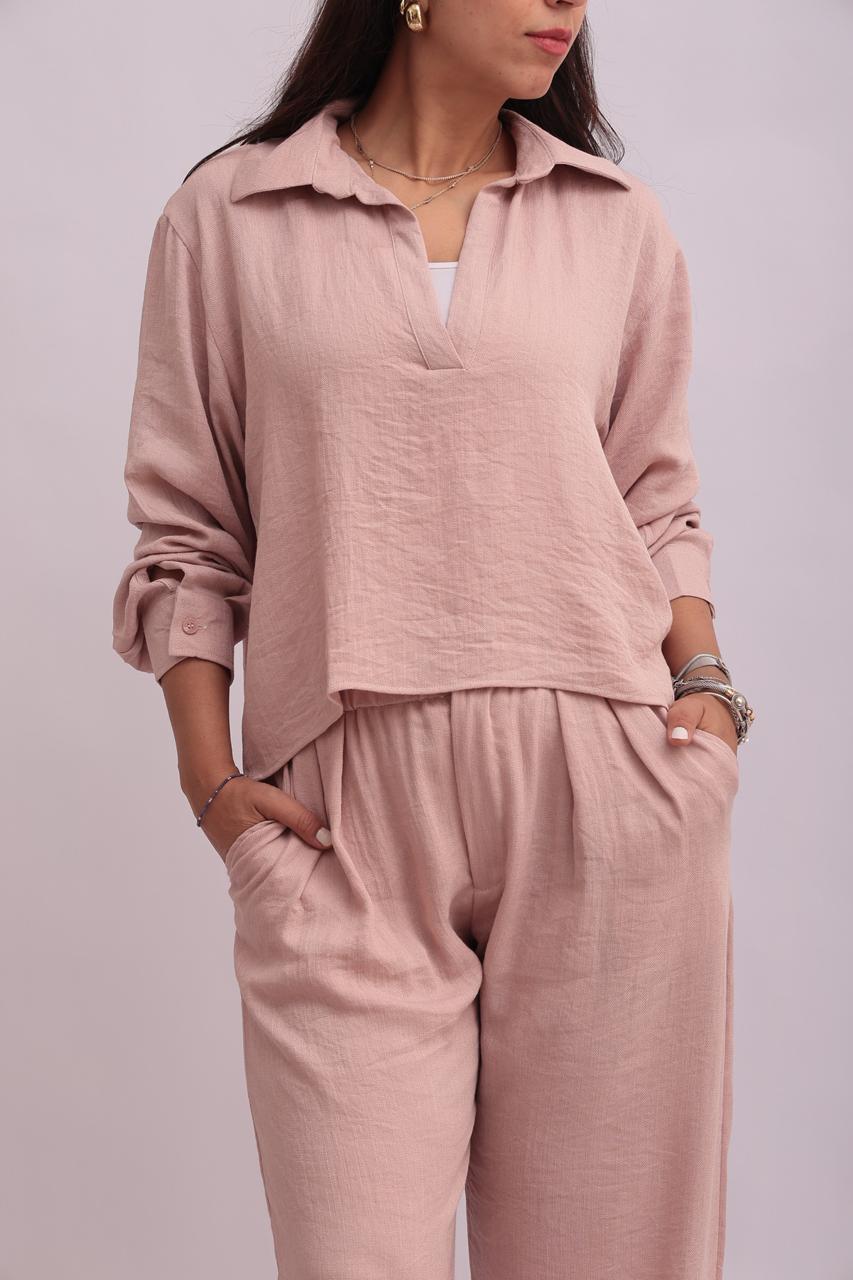 Close-up shot of the front of a blush pink linen shirt and matching trousers, highlighting the collar design and fabric texture.