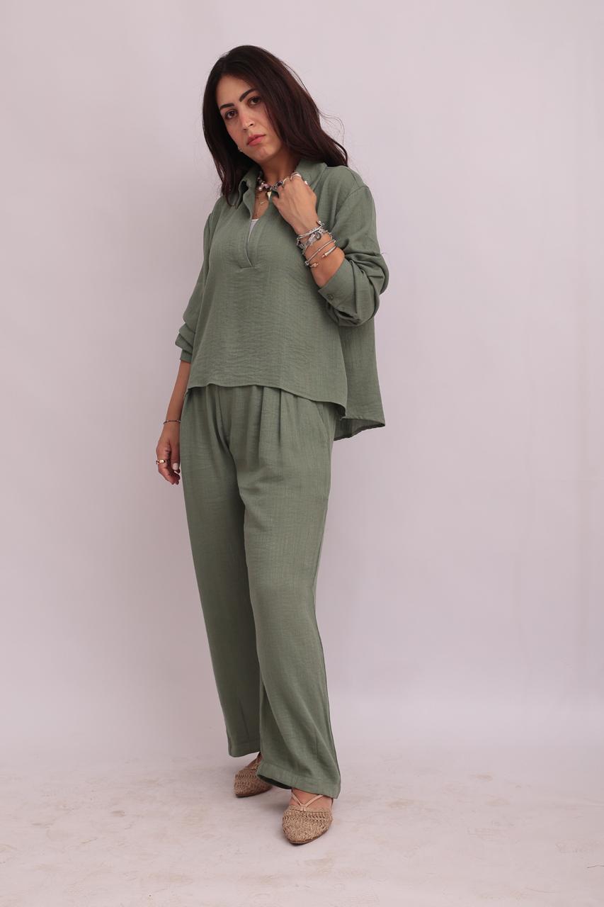 Front view of a model wearing a sage green linen pullover shirt and trousers set, looking forward.