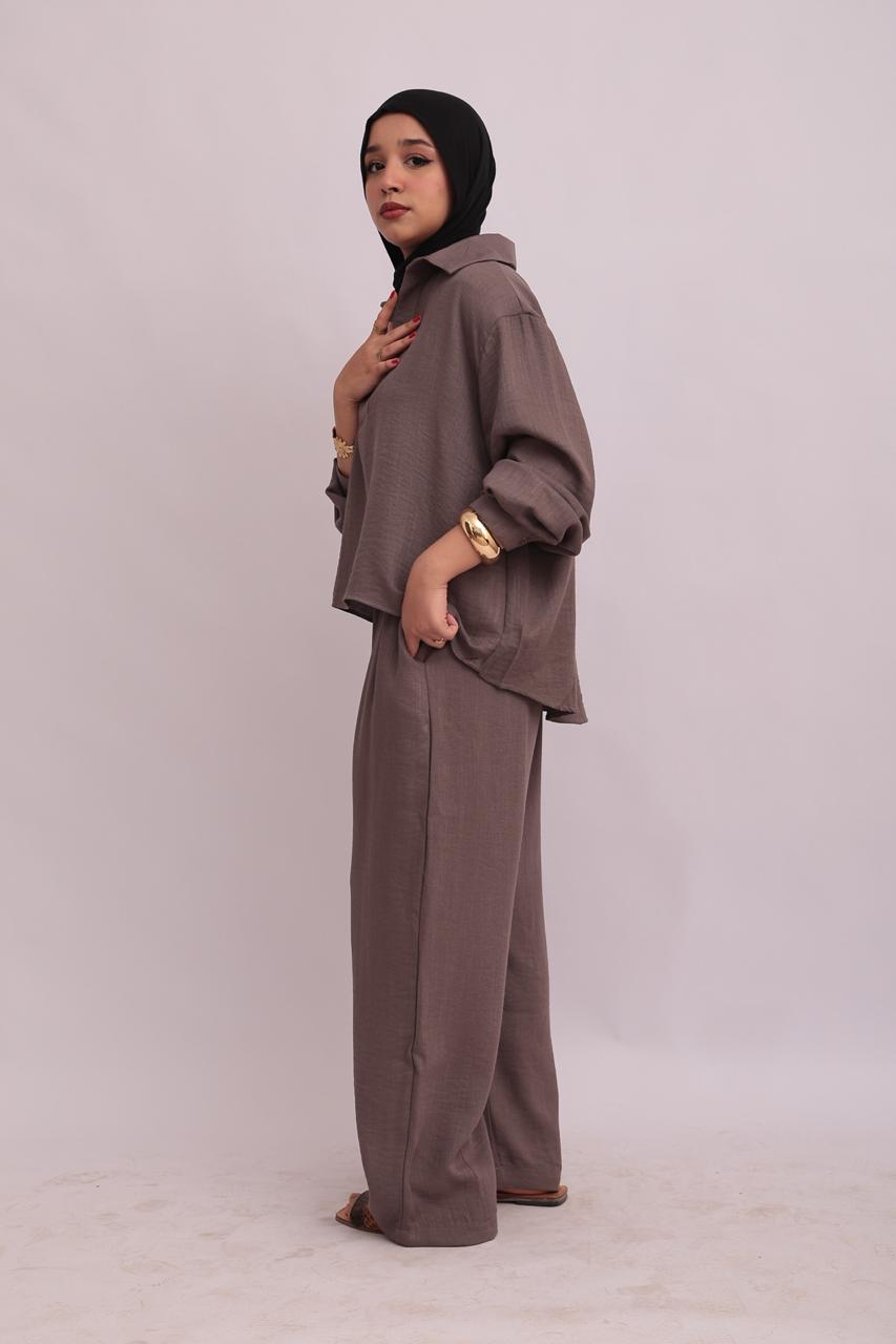 Close-up front view of a model wearing a taupe linen pullover shirt and trousers set, showing the collar structure.